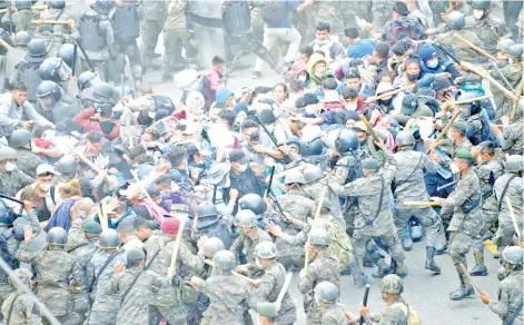  ?? — AFP photo ?? Honduran migrants, part of a caravan heading to the United States, clash with Guatemalan security forces in Vado Hondo.