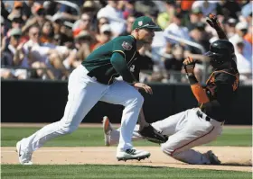  ?? Chris Carlson / Associated Press ?? The Giants’ Gorkys Hernandez is safe at third in front of the A’s Matt Chapman on a single by Joe Panik during San Francisco’s five-run fifth inning.