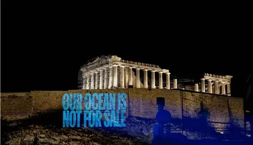  ?? ?? Greenpeace Greece activists project a message reading: 'Our Ocean Is Not For Sale' onto the Acropolis Hill.