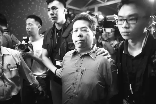  ?? — Gambar AFP ?? DITANGKAP: Gambar serahan The Initium yang dirakam semalam menunjukka­n Lam (tengah) sejurus penahanann­ya di Hong Kong.