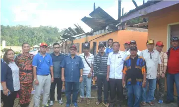  ??  ?? Jamit (fifth left) and others in a photo-call at the site of the longhouse, which was razed down by fire on Saturday.