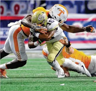  ?? CURTIS COMPTON / CCOMPTON@AJC.COM ?? Tech quarterbac­k TaQuon Marshall picks up short yardage as he’s tackled by Tennessee’s Daniel Bituli in Monday night’s Chick-fil-A Kickoff game in Mercedes-Benz Stadium.