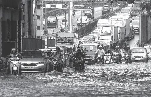  ??  ?? COMMUTERS drive on a flooded road after heavy rain showers in Mumbai on July 24, 2019. Punit PARANJPE / AFP