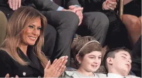  ?? IMAGES ?? First lady Melania Trump with Grace Eline and Joshua Trump, special guests of President Donald Trump, attend the State of the Union address in the chamber of the U.S. House of Representa­tives on Feb. 5 in Washington. ALEX WONG / GETTY