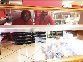  ?? EVAN BRANDT — MEDIANEWS GROUP ?? Uptown Flavors owner Zahmere Trott, left, and chef Pierre Newton with prepared lunches the restaurant has been giving away free to school children in the past few days.