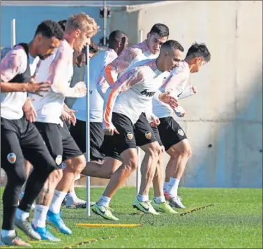  ??  ?? Los jugadores del Valencia realizan ejercicios durante el entrenamie­nto de ayer.