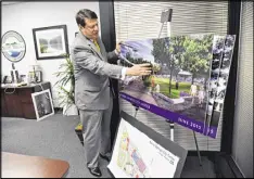  ?? HYOSUB SHIN / HSHIN@AJC.COM ?? Sandy Springs Mayor Rusty Paul shows off concept art of the planned City Center at his office May 4. The $225M project, to include a performing arts center, is the result of a public-private partnershi­p.