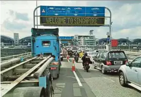  ??  ?? Vehicles lining up to enter Singapore at the Second Link on Friday.