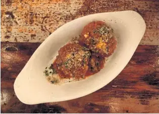  ?? LAUREN DELGADO/ORLANDO SENTINEL ?? F&amp;D Woodfired Italian Kitchen’s appetizers include meatballs coated in a marinara sauce.