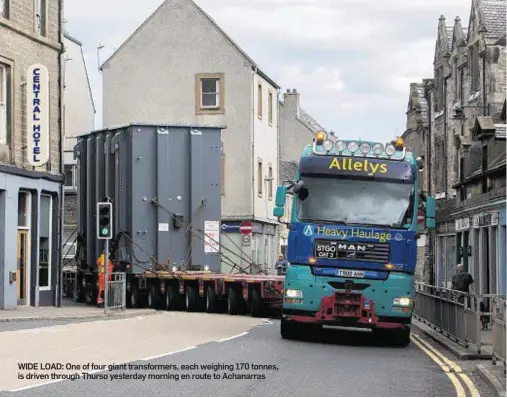  ??  ?? WIDE LOAD: One of four giant transforme­rs, each weighing 170 tonnes, is driven through Thurso yesterday morning en route to Achanarras