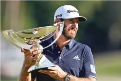  ?? JOHN BAZEMORE/ASSOCIATED PRESS ?? Dustin Johnson holds up the FedEx Cup trophy after winning the Tour Championsh­ip on Monday at Lake Golf Club in Atlanta.