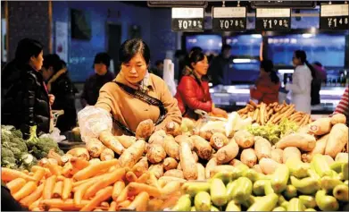  ?? GENG GUOQING / FOR CHINA DAILY ?? A customer shops for vegetables at a supermarke­t in Xuchang, Henan province. In November, food prices went up 5.9 percent year-on-year, with vegetable prices up 22.3 percent, according to the National Bureau of Statistics.