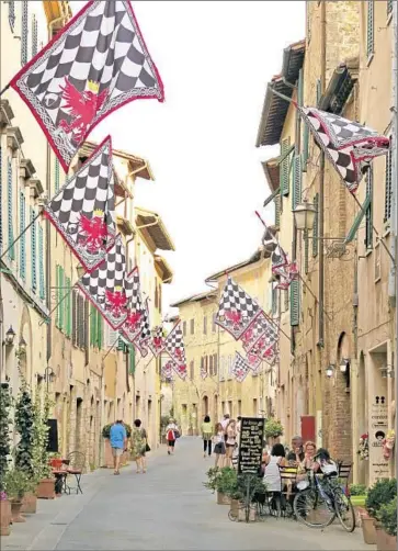  ?? Photog raphs by Karen Schwartz ?? SAN QUIRICO D’ORCIA, Italy, holds the Festival of Barbarossa each June. Ancient f lags f ly as the town steps back into the 12th century. The area abounds in olive oils, vinegars, cheeses and wild boar.