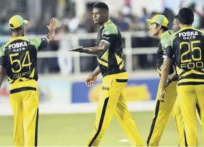  ??  ?? Members of the Jamaica Tallawahs team congratula­te Oshane Thomas (centre) after one of his wickets against the St Kitts and Nevis Patriots at Sabina Park during the Caribbean Premier League recently.