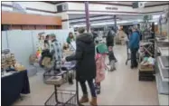  ??  ?? Customers at Parry’s look over goods during the indoor farmers market on Saturday, Jan. 12, 2019.