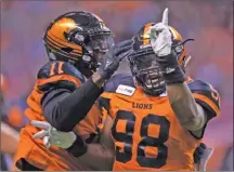  ?? The Canadian Press ?? B.C. Lions defensive end Ivan McLennan (98) celebrates with teammate Odell Willis after sacking Ottawa Redblacks quarterbac­k Trevor Harris during CFL action in Vancouver last Friday. The Lions won 26-14 and will visit the Montreal Alouettes this Friday for a 4:30 p.m. PT kickoff.