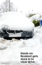  ??  ?? Hands on: Resident gets stuck in to clear drive
