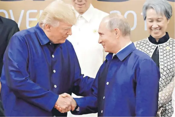  ??  ?? Donald Trump y Vladimir Putin estrechan la mano antes de tomarse una foto ayer en la cumbre APEC enDa Nang, Vietnam.