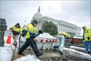  ?? J. SCOTT APPLEWHITE / ASSOCIATED PRESS ?? People clear snow from a security barricade on Capitol Hill in Washington on Tuesday.