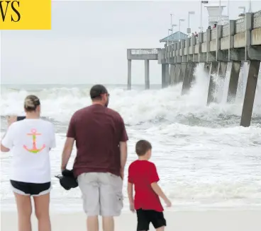  ??  ?? Waves crash against a fishing pier on Okaloosa Island in Fort Walton Beach, Fla., on Tuesday as Hurricane Michael approaches the northweste­rn part of the state. The hurricane is expected to make landfall on Wednesday afternoon. NICK TOMECEK / NORTHWEST FLORIDA DAILY NEWS VIA AP