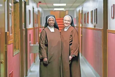  ?? MIKE DE SISTI / MILWAUKEE JOURNAL SENTINEL ?? Sister Maria Goretti (left) and Sister Immaculata stand in the hallway of the Carmelite Home for Boys in Wauwatosa. For a century, the Carmelite Home for Boys has taken in orphans and juvenile offenders. But now the last of the boys are being sent...