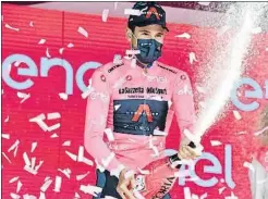  ?? JENNIFER LORENZINI / REUTERS ?? Filippo Ganna celebra la seva maglia rosa al podi de Torí