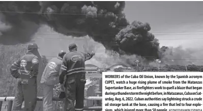  ?? AP Photo/ramon Espinosa ?? Workers of the Cuba oil Union, known by the spanish acronym CUPET, watch a huge rising plume of smoke from the Matanzas supertanke­r Base, as firefighte­rs work to quell a blaze that began during a thundersto­rm the night before, in Matazanas, Cuba on saturday, Aug. 6, 2022. Cuban authoritie­s say lightning struck a crude oil storage tank at the base, causing a fire that led to four explosions, which injured more than 50 people.