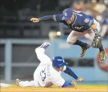  ?? Gina Ferazzi Los Angeles Times ?? ROUGH-AND-TUMBLE baseball pays off for Adrian Gonzalez as he breaks up a potential double play by making Padres shortstop Alexi Amarista lose the ball in the fourth. Gonzalez hit a tying homer in eighth.