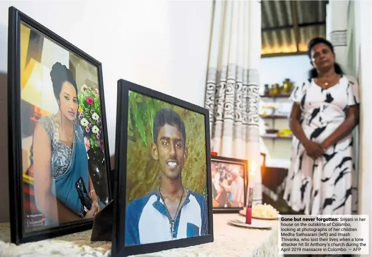  ?? ?? Gone but never forgotten: Sriyani in her house on the outskirts of Colombo, looking at photograph­s of her children Medha Sathsarani (left) and imash Thivanka, who lost their lives when a lone attacker hit St anthony’s church during the april 2019 massacre in Colombo. — afp