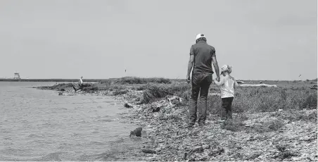  ?? Melissa Phillip / Staff photograph­er ?? Nancy Cornelius walks with her granddaugh­ter James, 5, along the Intracoast­al Waterway that borders the family’s land in Sargent.