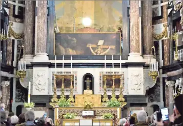  ?? Virginia Mayo / AP ?? Workers lower the painting “Elevation of the Cross” by Flemish painter Gerard Seghers at the St. Charles Borromeo church in Antwerp, Belgium. Three times a year, the Roman Catholic church switches the huge painting behind its main altar using an...