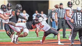  ?? NATHAN J FISH/THE OKLAHOMAN ?? Oklahoma State’s Collin Oliver (30) takes down Texas Tech’s Behren Morton (2) in the first quarter Saturday in Stillwater.