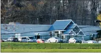  ?? GREG WOHLFORD — ERIE TIMES-NEWS VIA AP ?? Vehicles are parked outside the Pennsylvan­ia Internatio­nal Academy dorms, Wednesday, April 14, 2021, in Summit Township, Pa., which is housing a group of migrant children, about 146 girls ages 7-12, who were detained at the U.S.-Mexico border. The girls were flown to Erie Internatio­nal Airport, then transporte­d to the facility to receive temporary shelter.