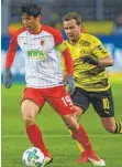  ?? FOTO: AFP ?? Nach dem Punktgewin­n beim BVB wollen Ja-cheol Koo – mit Mario Götze – und Kollegen nachlegen.