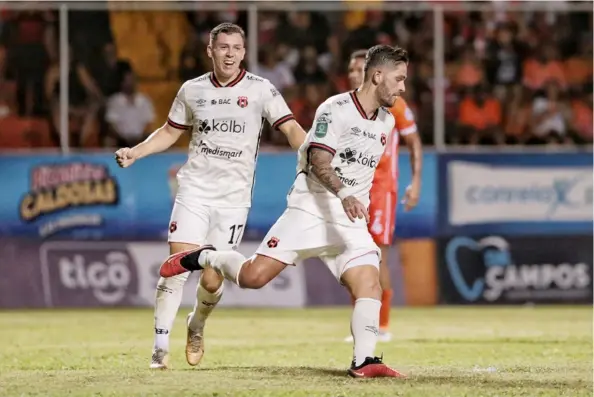  ?? JoHn durÁn ?? Jonathan Moya empieza el festejo de su gol, junto a Carlos Mora (17). La Liga arrancó el torneo con dos victorias.