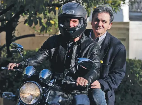  ?? ALKIS KONSTANTIN­IDIS / REUTERS ?? Varufakis conduce su famosa moto y lleva de paquete a Euclid Tsakalotos, su sucesor como ministro de Finanzas