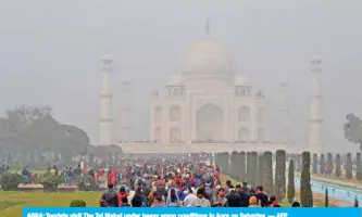  ?? — AFP ?? AGRA: Tourists visit The Taj Mahal under heavy smog conditions in Agra on Saturday.