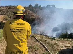  ?? Caleb Lunetta/ The Signal ?? A firefighte­r sprays burned brush to ensure the Carl Fire in Newhall is completely extinguish­ed Wednesday.