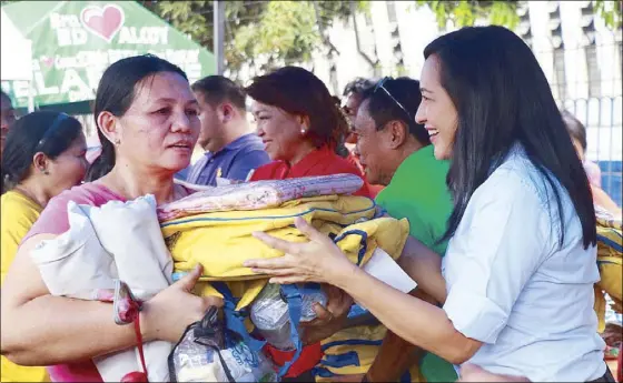  ??  ?? Quezon City Vice Mayor Joy Belmonte distribute­s relief packs to victims of a fire in Barangay Bagong Pag-asa on Saturday.