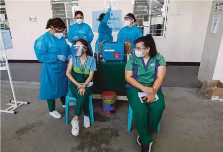  ?? EPA PIC ?? Health workers receiving a dose of the AstraZenec­a Covid-19 vaccine during a vaccinatio­n drive at a hospital in Paranaque City, Metro Manila, the Philippine­s, recently.