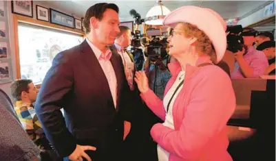  ?? ROBERT F. BUKATY/AP ?? Gov. Ron DeSantis speaks with a customer at the Red Arrow Diner on Friday in Manchester, New Hampshire.