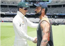  ?? Picture: GETTY IMAGES ?? GRACIOUS IN DEFEAT: Tim Paine, left, of Australia shakes hands with Virat Kohli of India after Australia claimed a 146-run victory in the second Test at Perth.