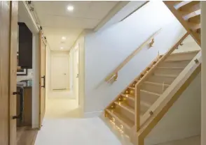 ??  ?? The engineered, white oak staircase features tempered glass with LED stringer lighting. Italian porcelain tile adds stylish contrast on the lower level as well.
