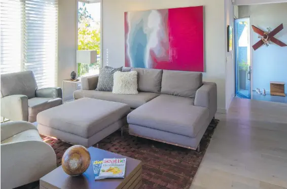  ??  ?? The monochroma­tic colour scheme in the remodelled living room offers a subtle background palette to let the art and rug pop. Trace says the art has sentimenta­l value because her partner, Reid, a music fan, “traded all these records for that piece.”