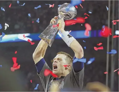  ?? STAFF PHOTO BY NANCY LANE ?? THE KING: Patriots quarterbac­k Tom Brady celebrates with the Lombardi Trophy after winning his fifth Super Bowl last night in Houston.