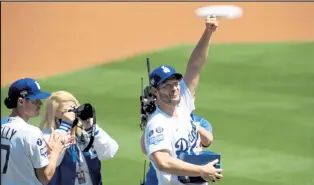  ?? HARRY HOW / Getty Images ?? The Dodgers’ Clayton Kershaw holds up his World Series ring during the team’s pregame ceremony Friday at Dodger Stadium.