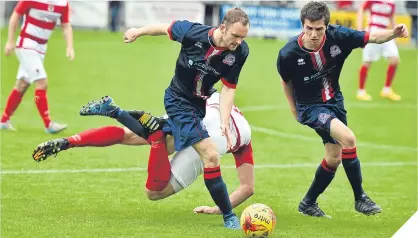  ??  ?? Turriff’s Christophe­r Herd (left) and Paul Young combine to stop Bonnyrigg’s Kieran McGachie.