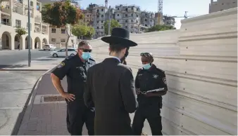  ?? ( Olivier Fitoussi/ Flash90) ?? POLICE OFFICERS enforce the emergency regulation­s in Jerusalem’s Ramat Shlomo neighborho­od yesterday.