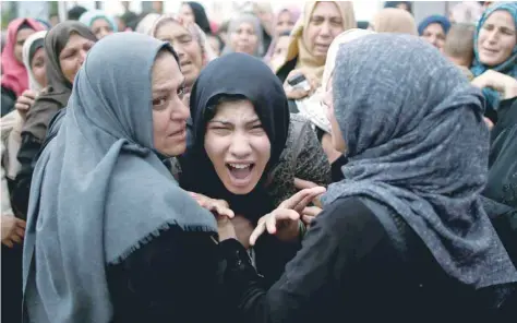  ?? — Reuters ?? A relative of Palestinia­n Naji al Zaneen, who was killed in an Israeli air strike, reacts during his funeral in the northern Gaza Strip, on Wednesday.