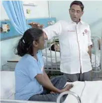  ??  ?? Subramania­m chats with a patient at the Segamat Hospital before presenting Deepavali gifts to some 300 patients.